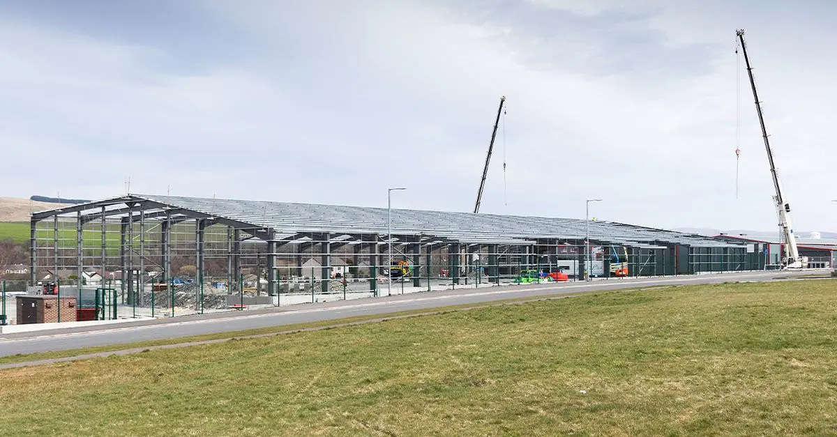 The steel frame of the Kirkconnel extension rising beside the existing factory, June 2022